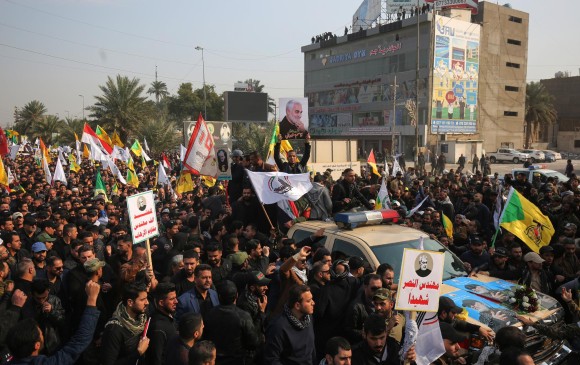 Iraquíes rodean un automóvil que lleva el ataúd del general iraní Qasem Soleimani durante una procesión fúnebre en Bagdad. FOTO AFP