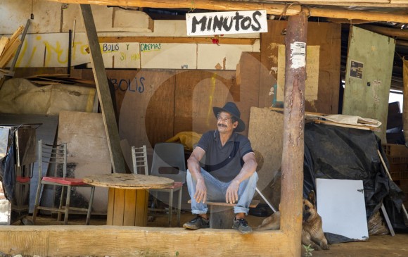 Óscar vende minutos a celular y bolis. Dice que como fundador, su casa sería la última en renovarse. Por eso apenas ahora, tras 25 años, empezó su reconstrucción. FOTO EL COLOMBIANO