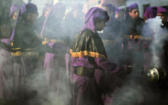 Un participante en la procesión quema incienso al paso de la imagen de Jesús de la Merced en el centro histórico de la capital de Guatemala. EFE/ Ulises Rodríguez