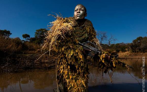Petronella Chigumbura (30), miembro de una unidad femenina contra la caza furtiva, participa en un entrenamiento de camuflaje en Zimbabwe. FOTO Brent Stirton