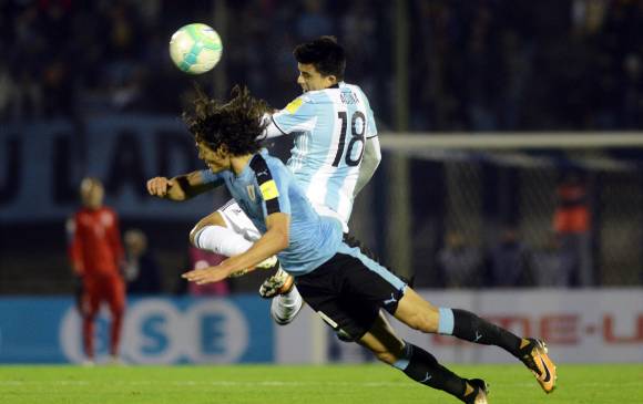 Édinson Cavani y Marcos Acuña, otro duelo que se vio en el estadio Centenario de Montevideo. El clásico terminó sin goles, a pesar de la presencia de grandes artilleros. FOTO Reuters