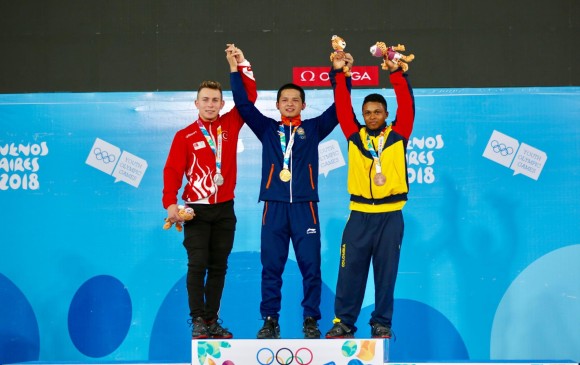 Estiven Villar (derecha) celebra en el podio la medalla de bronce obtenida en el levantamiento de pesas. FOTO CORTESÍA COMITÉ OLÍMPICO COLOMBIANO