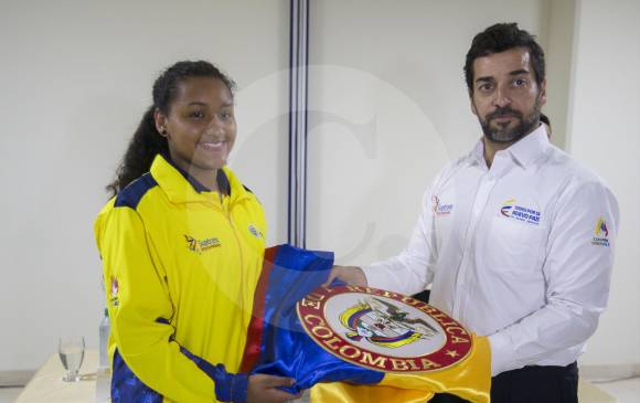 Esteysy Díaz recibió con satisfacción, de parte del subdirector de Coldeportes Afranio Restrepo, la bandera de Colombia. La bogotana espera repetir título suramericano. FOTO Donaldo Zuluaga