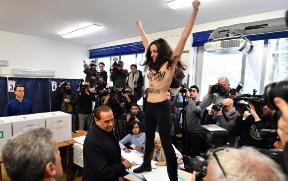 La postal de estas elecciones fue cuando el polémico exmandatario Berlusconi fue increpado por una activista de Femen. FOTO EFE