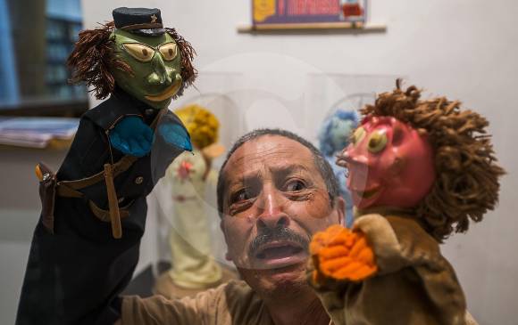 Néstor Gaibor Maldonado interactúa con el Guardia y Aníbal, personajes de los Cuentos de Javier Villafañe junto a la exposición de títeres de la Biblioteca de Itagüí. FOTO Julio César Herrera