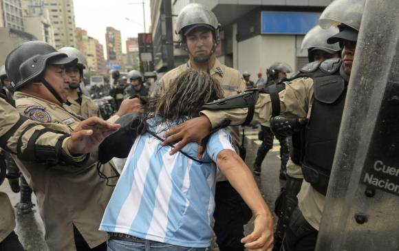 miembros de la Policía Nacional arrestan a un opositor del presidente de Venezuela, Nicolás Maduro, durante una protesta en Caracas, Venezuela, el 12 de febrero de 2015. FOTO AFP