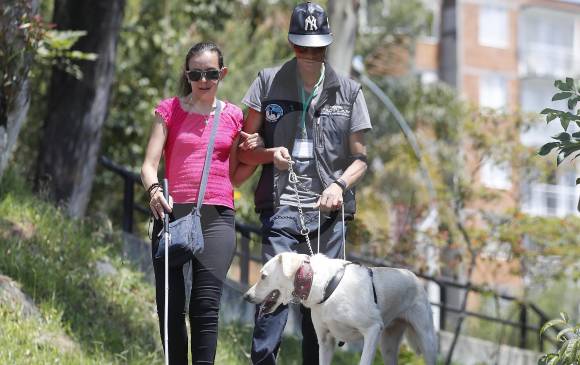 Luisa Fernanda y Luis Ómar caminan por el sector de La Aurora, guiados por Sacha que los alerta sobre las gradas que se encuentran al bajar por un sedero peatonal. Manuel Saldarriaga