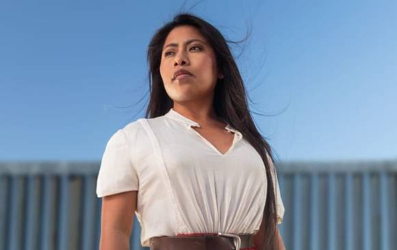 Yalitza frente al muro vistiendo una blusa blanca de tirantes y falda roja, típica de las mujeres de su natal Oaxaca. Foto: IG @yalitzaapariciomtz