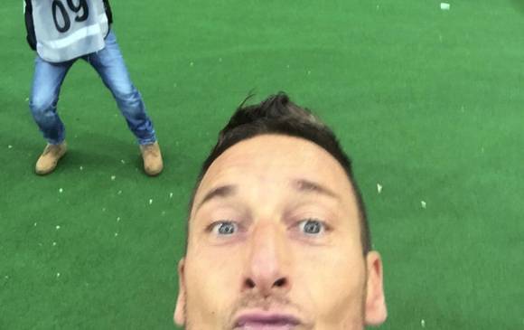 Luego de anotar el tanto del empate, Totti tomó el teléfono móvil de Guido Nanni, entrenador de porteros de la Roma, y se sacó una foto con los “ultras” del club al fondo. FOTO AP