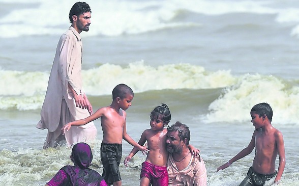 Miles de habitantes de la ciudad de Karachi decidieron, ante el calor que golpeó la zona, refrescarse en el mar con sus familias durante las horas que generaron más bochorno el día de ayer. FOTO afp