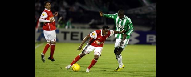 Atlético Nacional lucha contra todo | Colprensa, Bogotá | Víctor Ibarbo disputa la pelota con Luis Yanes, el delantero que abrió la cuenta del triunfo santafereño frente a Nacional en el estadio El Campín, de Bogotá. Los verdes regresaron tristes ayer a Medellín, ahora pensando en dos duelos clave ante América y Medellín en el Atanasio.
