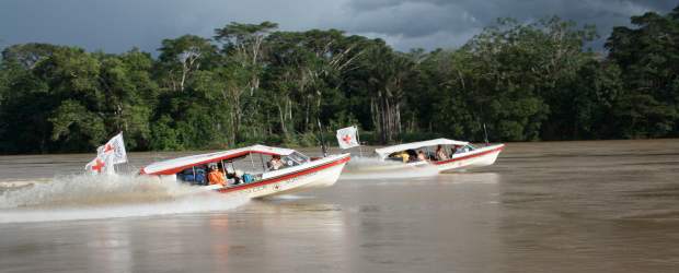 Región del bajo Caguán está enferma de olvido | Cortesía Cicr | Las dos lanchas del CICR con el equipo médico, compuesto por dos médicos, cuatro enfermeras y una odontóloga, se trasladan por el río Caguán de la comunidad de Santo Domingo a la de Monserrate. Llevan medicamentos que son entregados gratuitamente a quienes asisten a las brigadas. En la otra imagen, Francisco, uno de los médicos, revisa a Jeison, el niño mordido por una culebra.