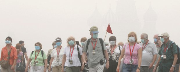 Varias embajadas retiran personal de Moscú, atrapada por el humo y el calor | Reuters | Un grupo de turistas usa mascaras para transitar por las calles de Moscú debido al humo y las cenizas.