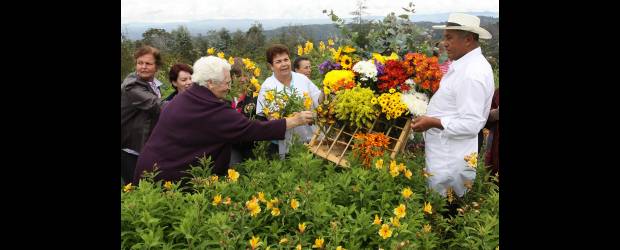 Las flores son para las silletas y los turistas | Donaldo Zuluaga | Don William estuvo listo para atender a los turistas, que esta vez vinieron de Pasto. Le preguntaron sobre la silleta, cuánto llevaba de silletero y si le pesaba mucho. Y hasta le ayudaron a empezar a poner las flores y él los dejó que la cargaran y se tomaran fotos.