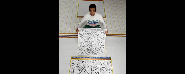 Juan vive en función de números | Hernán Vanegas | Juan Ramiro Osorio Restrepo, Envigadeño Ejemplar 2009, sostiene arriba el gran crucigrama de 10.000 casillas. Abajo, izquierda, enseña su novedoso Decadrez y a la derecha parte de los trofeos adquiridos en atletismo.