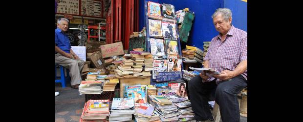 Tienda de Javier un oasis para los lectores | Róbinson Sáenz | Por 300 pesos, Javier Gómez cambia libros de pistoleros, revistas de Selecciones, Más Allá, Play Boy. También compra y vende imanes, así como "monedas antiguas y billetes" en su puesto de Bolívar con Amador. Su esposa (de pie en la foto inferior izquierda) Amparo Sánchez, va a visitarlo con frecuencia.