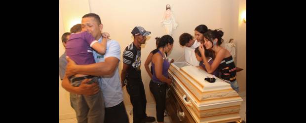 Una piñata que se festejará en el cielo | Hernán Vanegas, Enviado Especial, Amagá | En primer plano, Alexánder, el papá, busca apoyo en su otro hijo, de seis años, que se salvó de los disparos. El pueblo está conmovido por el episodio y acompañará hoy a la familia en la ceremonia exequial.