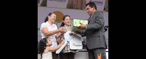 Marisol recibió las llaves de su vivienda, en Paisajes | Robinson Sáenz | Marisol Marulanda Zapata sostiene la llave simbólica de su nueva casa, mientras su mamá, Victoria, recibe el obsequio entregado por Comfenalco, Cotrafa y Confiar. La pequeña Valeria, a un lado, luce emocionada.