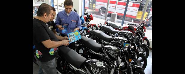 Un mercado que viene acelerado | Julio César Herrera | Óscar Giraldo (a la izquierda) encontró en comprar una moto para su empleado Jhonson Parias (centro) una solución laboral y de movilidad.