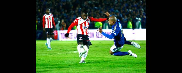 Una semifinal tiene pinta azul | Christian Castillo, Colprensa, Bogotá | Juan Esteban Ortiz no les permitió el libre tránsito a los jugadores del Junior, como en esta acción ante Jossymar Gómez. Ese trabajo fue fundamental para que Millonarios paseara y goleara a los costeños en El Campín de Bogotá.