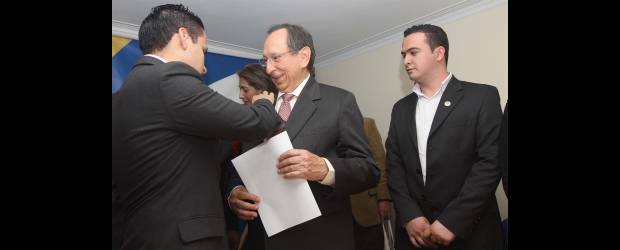 Juan Gómez Martínez se lanzó en busca de consenso | Hernán Vanegas | Lucas Cañas, vicepresidente del Directorio Nacional Conservador, impone un escudo del partido a Juan Gómez Martínez, quien es acompañado por Carlos Yépez, presidente del Concejo de Donmatías, el concejal más joven del país.