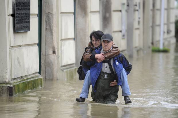 AP - Un voluntario lleva a una mujer de su lugar de trabajo fuera del casco antiguo de Passau, Alemania meridional.
