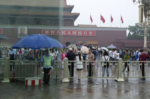 AP - 24 de mayo 2014. Un guardia de seguridad controla un carril destinado a las bicicletas, en una zona delimitada frente a la Puerta de Tiananmen.