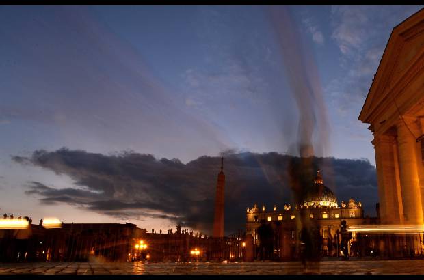 AFP - La gente camina en la plaza de San Pedro en la madrugada el 29 de octubre de 2014 en el Vaticano.