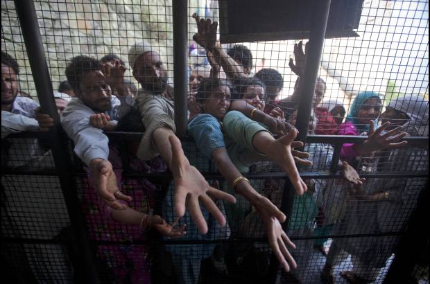 AP - Devotos musulmanes extienden sus manos para recibir ofertas en las afueras de un templo en el primer d&#237;a de Ramad&#225;n, en Srinagar, India.