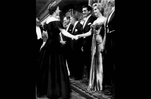 AP - Foto tomada el 10 de octubre de 1956 mientras Marilyn Monroe a la derecha, saluda a la reina Isabel II de Inglaterra.