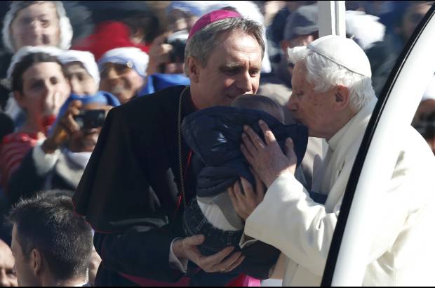 REUTERS - ... y con una parada puntual para coger en brazos a un recién nacido y bendecirlo.