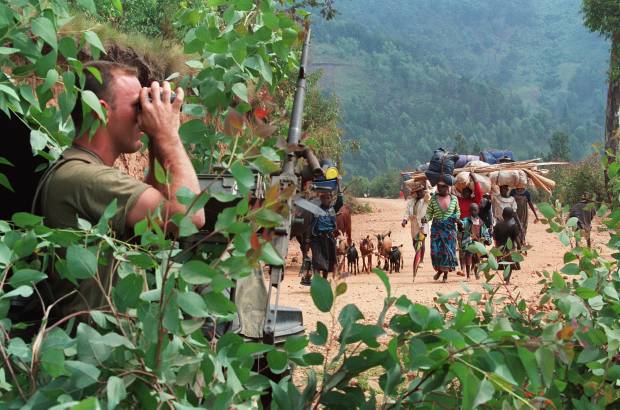 AFP - En esta foto de archivo del 12 de julio de 1994, un soldado francés que se escondía detrás de un árbol, miraba a través de binoculares cómo miles de personas que huían de los sangrientos combates entre el ejército de Ruanda y el Frente de Liberación Nacional se dirigían al campo de refugiados de Kivumu, al oeste del país.