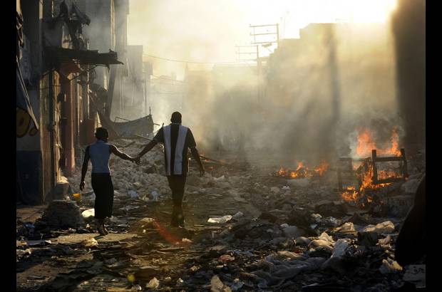 Reuters - Esta foto llamada Life Amid the Ruins (vida entre las ruinas) de Carol Guzy del Washington Post muestra a una pareja que camina entre los escombros de Puerto Pr&#237;ncipe, Hait&#237;.