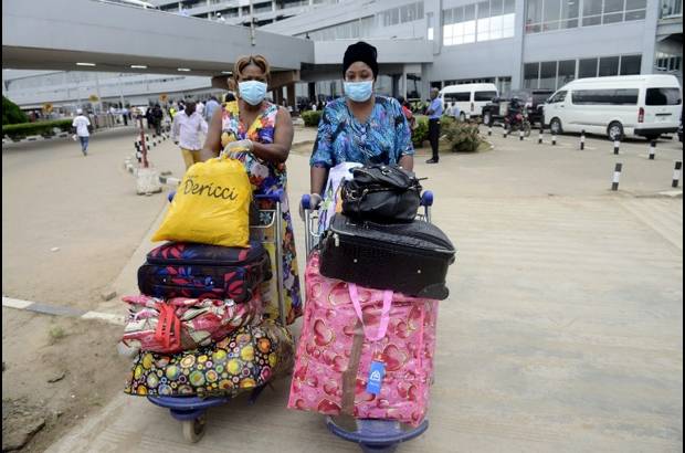 AFP - En el aeropuerto de Lagos, Nigeria, pasajeros usan m&#225;scaras y guantes para protegerse del virus del &#233;bola.