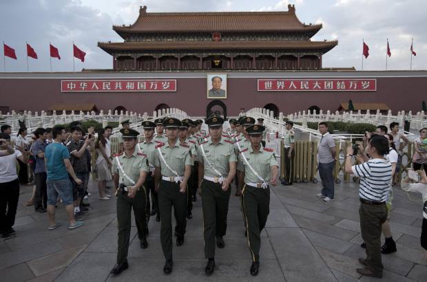 AP - 28 de mayo de 2014. Marcha de Polic&#237;as chinos fotografiada por visitantes a la Puerta de Tiananmen.