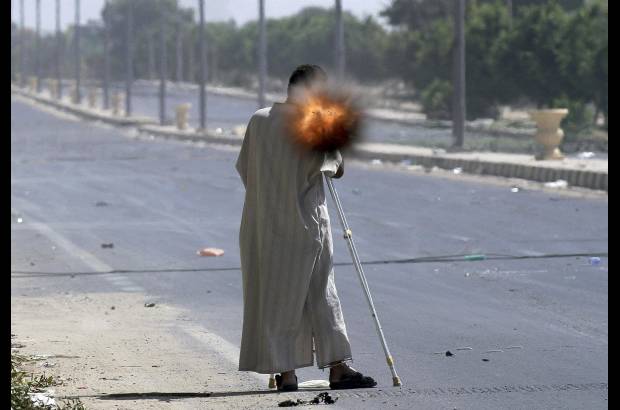 Reuters - Un rebelde con muletas disparando una granada propulsada por cohete mientras combatía en la ciudad de Sirte, Libia.