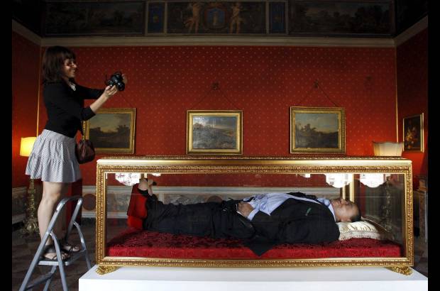 Foto Reuters - Los autores imaginan un Berlusconi con la corbata desabrochada; en la mano derecha, un ejemplar de la revista Una historia italiana, que el pol&#237;tico envi&#243; en su d&#237;a a las familias italianas y en el que publicitaba su trayectoria.
