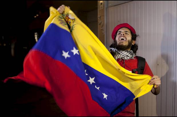 AP - Un mexicano ondea la bandera venezolana frente a la embajada de Venezuela en la Ciudad de M&#233;xico, en homenaje a Hugo Ch&#225;vez.