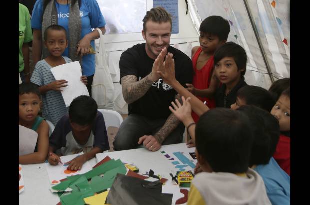 AP - David Beckham interact&#250;a con peque&#241;os sobrevivientes del tif&#243;n Haiyan durante su visita a Filipinas.