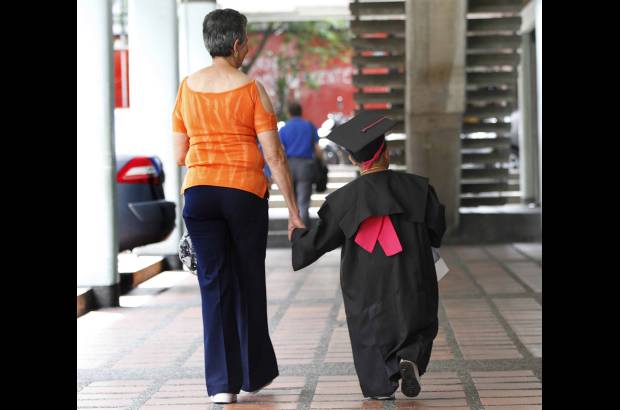 Foto Hernán Vanegas - De la mano de su abuela Luez Elena Balvín, el bachiller llegó al teatro Porfirio Barba Jacob a recibir el diploma.