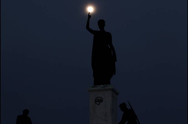 AP - Esta imagen es en Nicosia, Chipre. La Luna se levanta detrás de una estatua que representa la libertad de Chipre.
