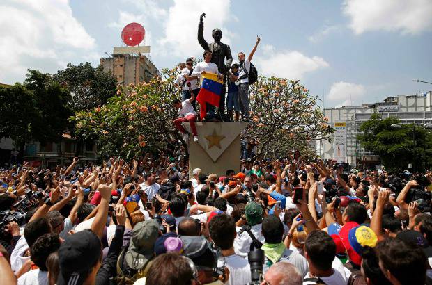 Reuters - Con la bandera de Venezuela en la mano, se trep&#243; en un monumento p&#250;blico durante la manifestaci&#243;n de sus seguidores que se oponen al gobierno de Nicol&#225;s Maduro.