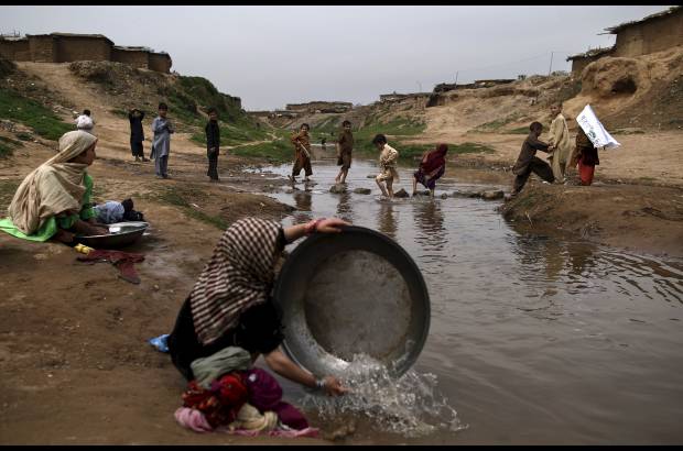 AP - Niñas pakistaníes lavan su ropa en un arroyo contaminado en un barrio pobre en las afueras de Islamabad, Pakistán.