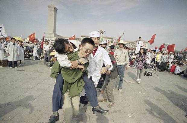 AP - 16 de mayo de 1989. Un estudiante en el tercer d&#237;a de huelga de hambre se desmaya y lo cargan para ser atendido por m&#233;dicos, en la plaza de Tiananmen.