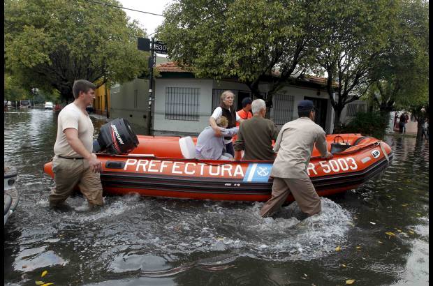 Reuters - Miembros del Servicio de Guardacostas de Argentina ayudan a dos mujeres a salir de su residencia en medio de las inundaciones, despu&#233;s de las fuertes lluvias que afectaron gran parte de la ciudad de La Plata.