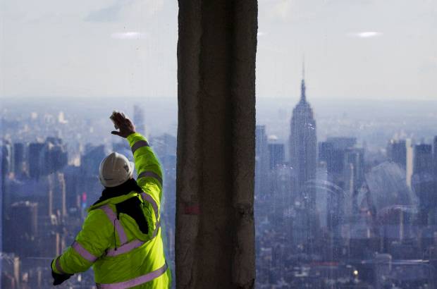 Reuters - Vista del Empire State Building mientras un trabajador limpia las ventanas del piso de observación número 100 en el edificio One World Trade Center.