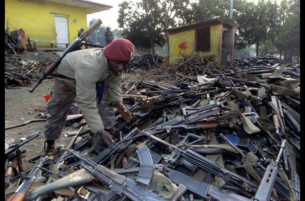 Reuters - Un soldado de Zaire inspecciona montones de armas confiscadas a las tropas del gobierno de Ruanda después de haber huido de la ciudad fronteriza de Gicenyi el 18 de julio de 1994. La masacre supuso el exterminio de entre el 20 y el 40 por ciento de la población de Ruanda, entonces el país más densamente habitado de África con siete millones de personas.