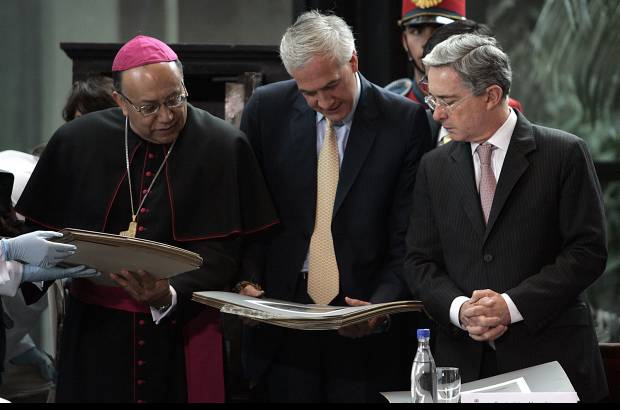 Reuters - Emocionados el presidente Álvaro Uribe, el cardenal Francisco Nieto y el alcalde Samuel Moreno ven los documentos que albergaba la urna centenaria.