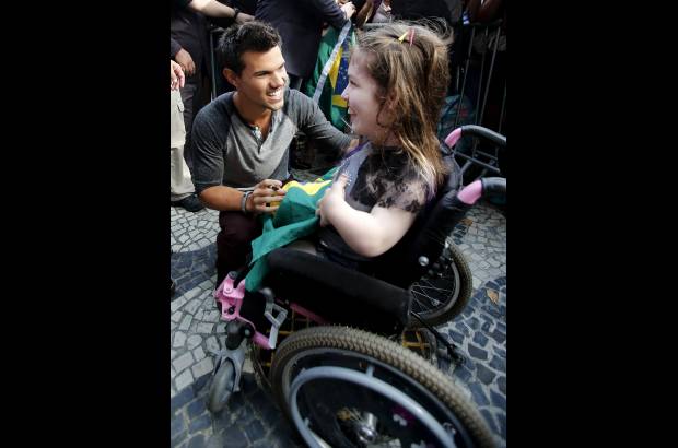Reuters - Taylor Lautner posa al lado de una ni&#241;a de 14 a&#241;os.
