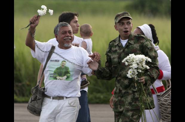 Reuters - Gustavo Moncayo, padre del uniformado y Mar&#237;a Stella Cabrera, la madre, le entregaron margaritas blancas.
